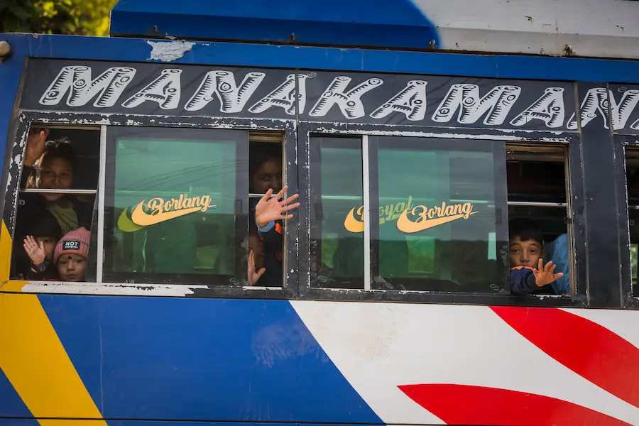 Kinder winken aus dem Bus - Manalsu Circuit Trek